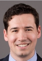 Smiling man with short dark hair.