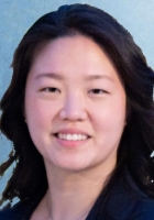 Smiling person with long wavy black hair.