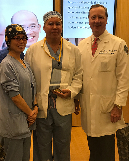Drs. Sakura Kinjo and Tad Vail stand with Jay Beebe as he holds his award
